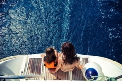 Girl and her mother enjoying vacation on sailboat